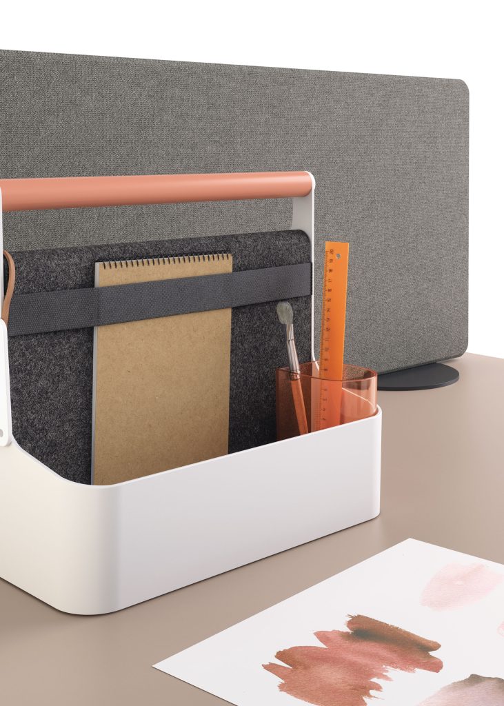 YouMe toolboxe blanche avec poignée en acier thermolaquée rose. La boxe contient un pot à crayon et un carnet.