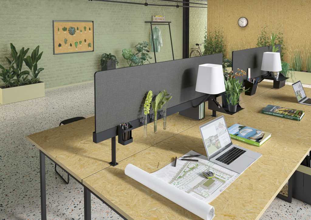 Bureaux faces à faces séparés d'un écran acoustique en tissu gris avec un support permettant de disposer des rangements.