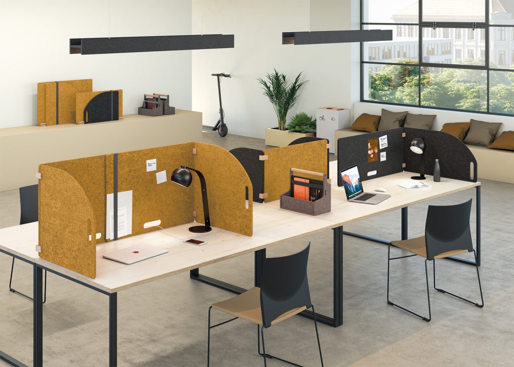 Espace de travail avec bureau commun divisé par des écrans acoustiques en feutre PET colorés, mobiles et modulables.