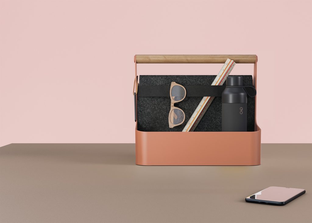 YouMe pink toolbox with wooden handle and black strap. The toolbox contains a water bottle, a ruler, and glasses.