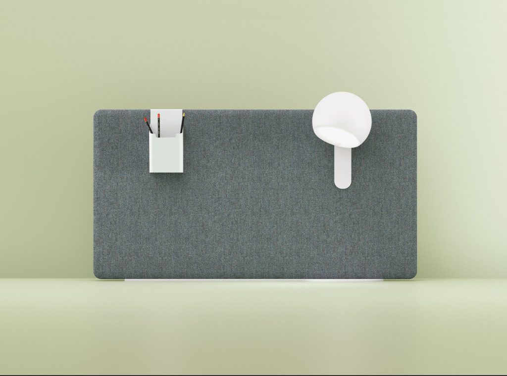 Studio background with gray fabric acoustic screen on which is placed a small lamp and a storage pot.
