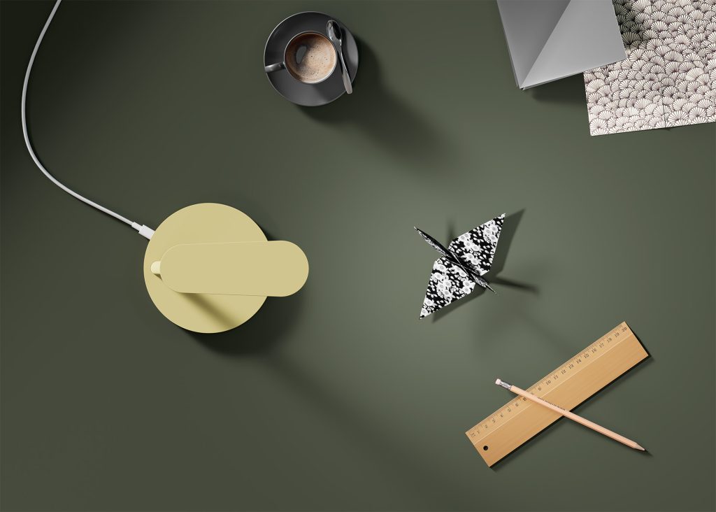 Modern desk lamp in putty color, viewed from above on a worktop.