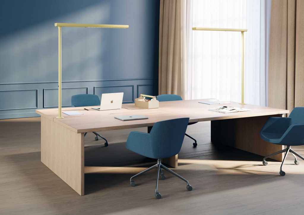 Desk with panel legs featuring two yellow floor lamps fixed to the desk and placed across both widths to cover the work surface.