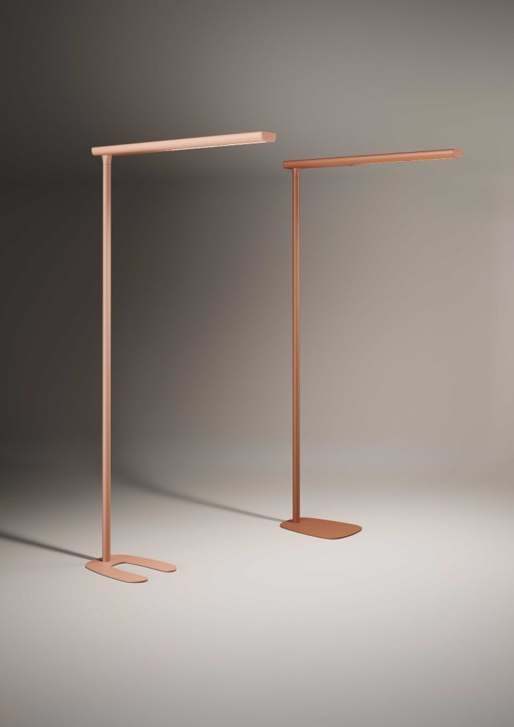 Fond studio avec deux lampadaires sur pied, un rose avec socle U et un terra cotta avec socle rond.